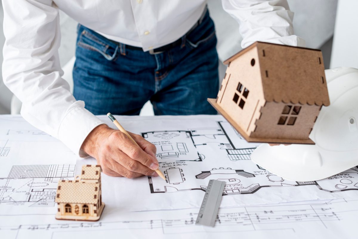 Un constructeur de maison dessine un plan de maison suite à une demande de projet immobilier.
